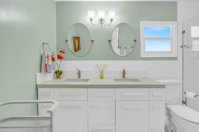 bathroom with vanity, toilet, and tile walls