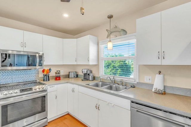 kitchen featuring pendant lighting, white cabinetry, stainless steel appliances, and sink