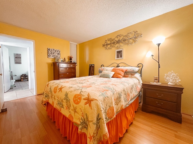 bedroom featuring light wood-style flooring and a textured ceiling