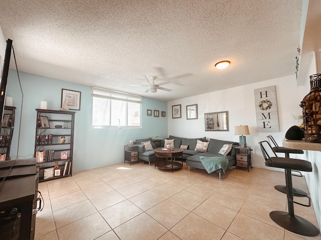 living area with light tile patterned floors, a textured ceiling, and a ceiling fan