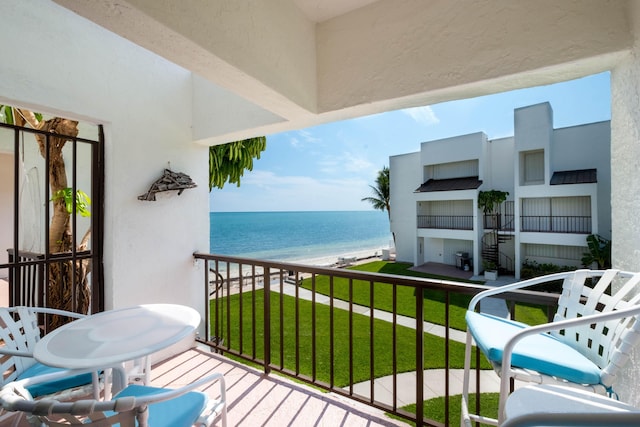 balcony featuring a water view and a beach view