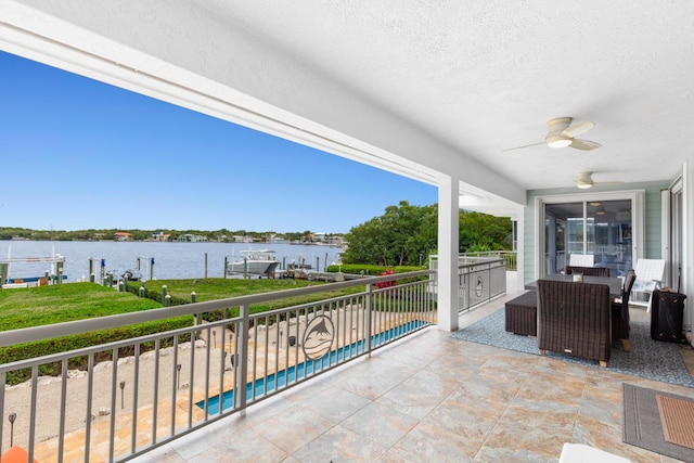 balcony with a water view and ceiling fan