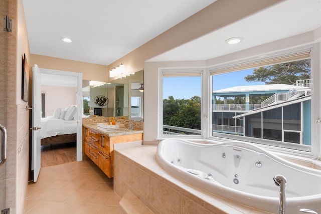 bathroom featuring vanity, a relaxing tiled tub, and tile patterned floors