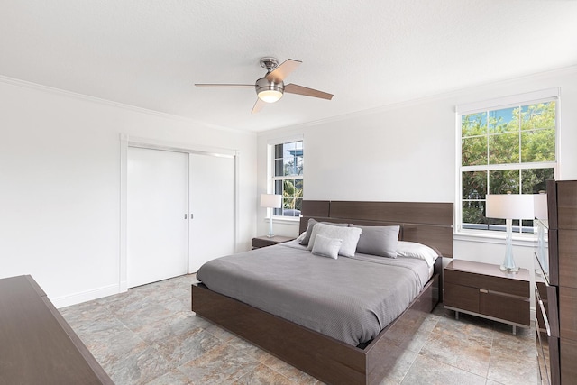 bedroom with a textured ceiling, ornamental molding, a closet, and ceiling fan