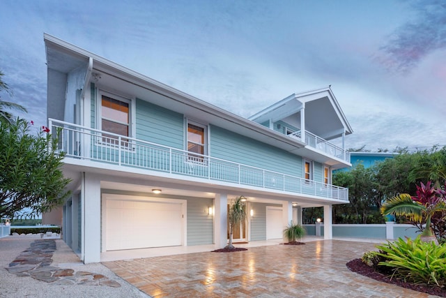 view of front of property featuring a balcony and a garage