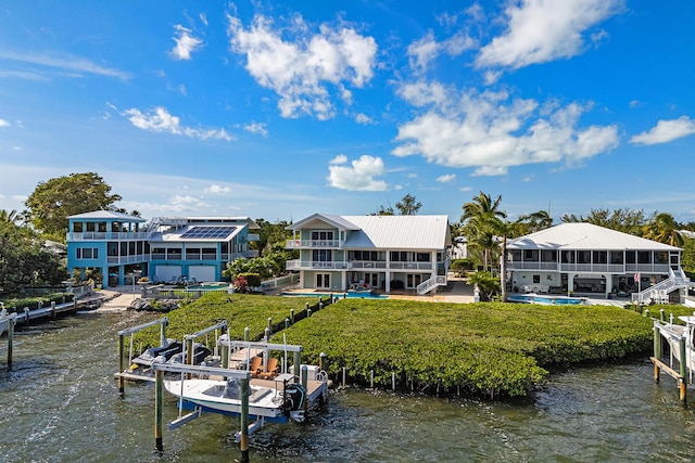 view of dock featuring a pool, a yard, and a water view