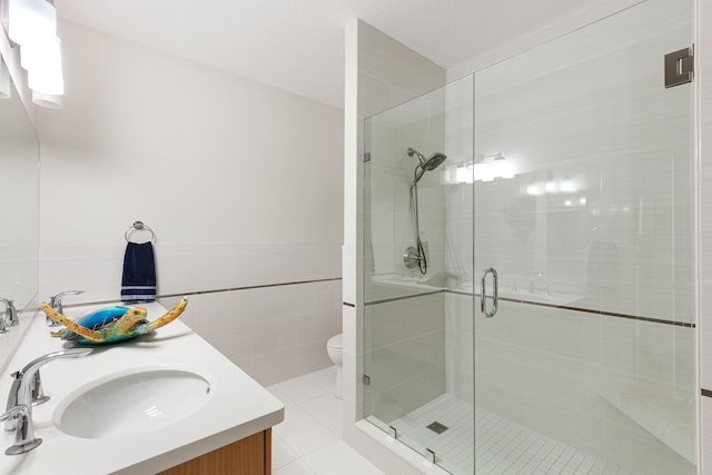 bathroom featuring walk in shower, tile patterned floors, toilet, tile walls, and vanity