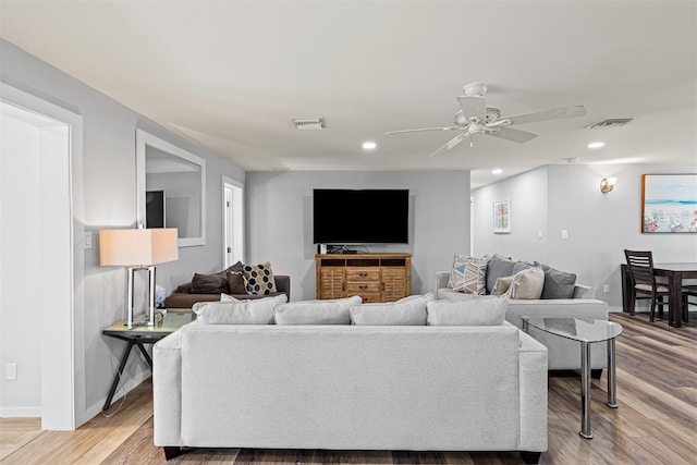 living room featuring ceiling fan and light hardwood / wood-style floors