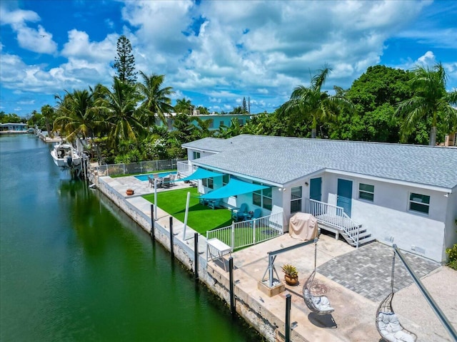 rear view of house featuring a patio area and a water view