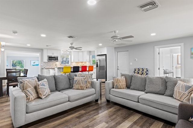 living room featuring hardwood / wood-style floors and ceiling fan with notable chandelier