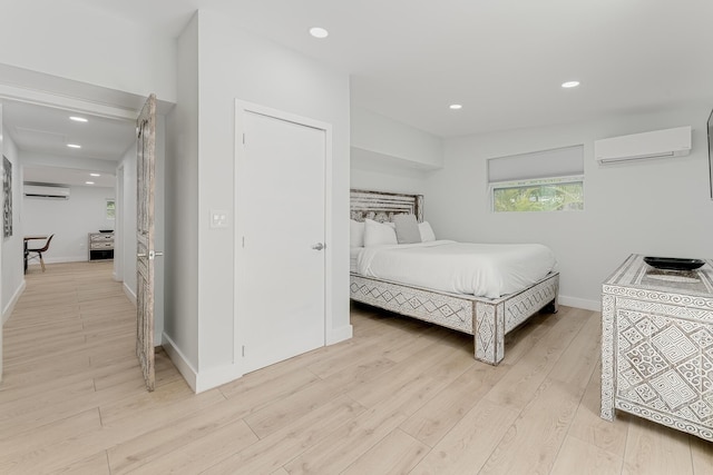 bedroom featuring a wall mounted AC and light wood-type flooring