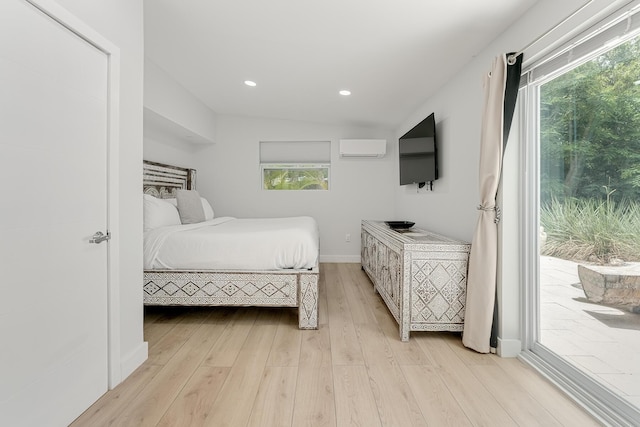 bedroom with access to outside, light hardwood / wood-style flooring, and an AC wall unit