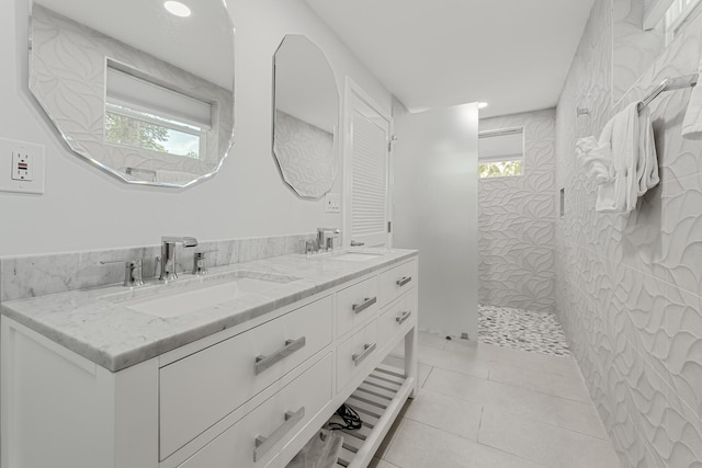 bathroom with vanity, a tile shower, and tile patterned floors