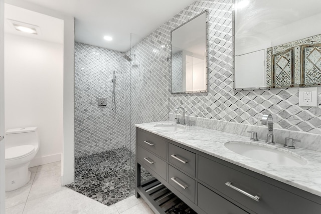 bathroom with tiled shower, tile patterned floors, toilet, vanity, and backsplash