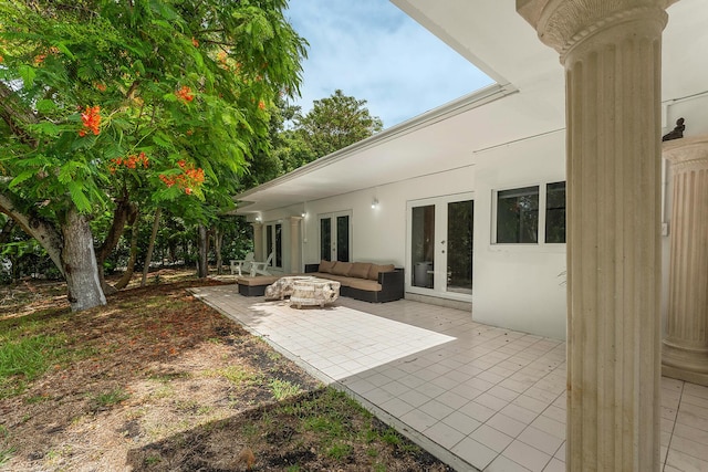 view of patio with an outdoor living space with a fire pit and french doors