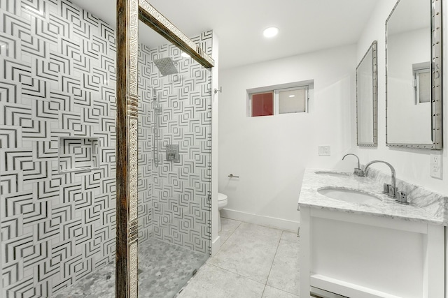 bathroom featuring tile patterned flooring, vanity, toilet, and a tile shower