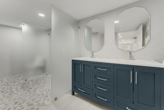 bathroom with tasteful backsplash, tile walls, vanity, walk in shower, and tile patterned floors