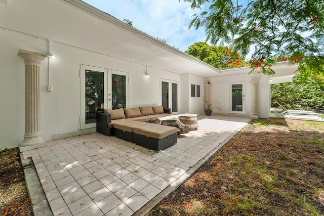 rear view of property with a patio, an outdoor living space with a fire pit, and french doors