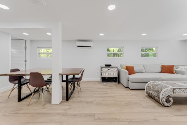 living room featuring a wall unit AC and light hardwood / wood-style floors