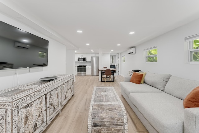 living room featuring a wall mounted AC and light hardwood / wood-style floors