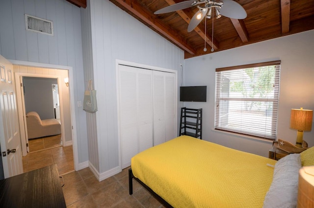 bedroom featuring wood ceiling, tile patterned floors, a closet, and beamed ceiling