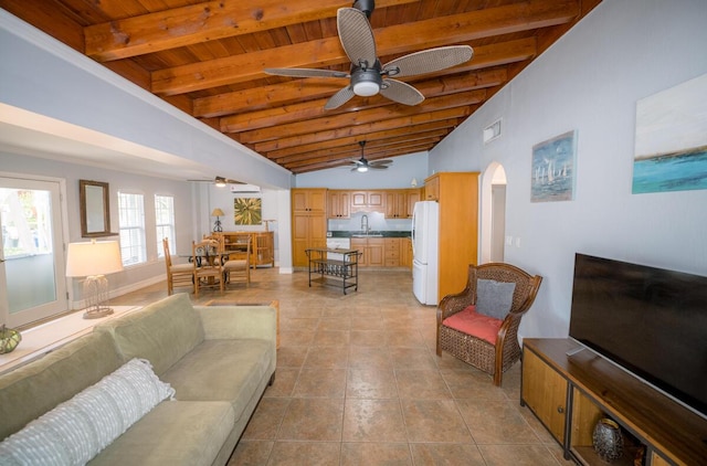 tiled living room with wood ceiling, ceiling fan, sink, and vaulted ceiling with beams