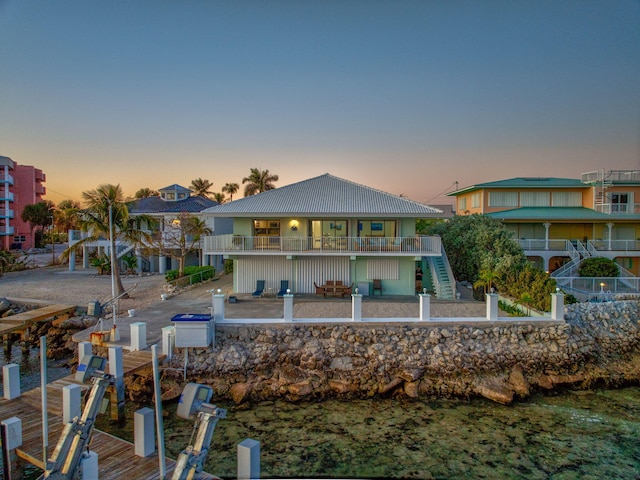 33 Kyle Way, Marathon, FL 33050 - back of house at dusk featuring stairway, boat lift, and a balcony