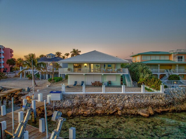 33 Kyle Way, Marathon, FL 33050 - back of house at dusk featuring stairway, boat lift, and a balcony