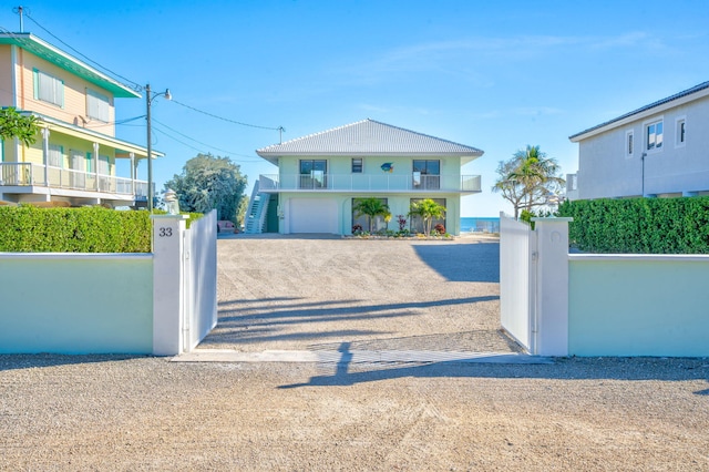 33 Kyle Way, Marathon, FL 33050 - beach home with driveway, a fenced front yard, an attached garage, a balcony, and a gate