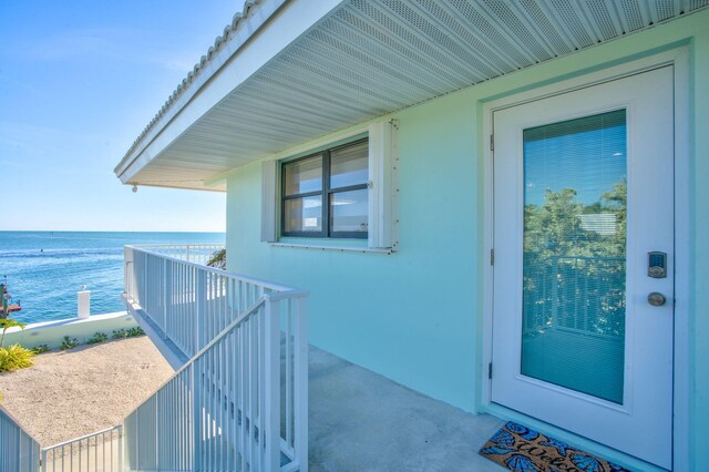 33 Kyle Way, Marathon, FL 33050 - doorway to property featuring a water view, a balcony, and stucco siding