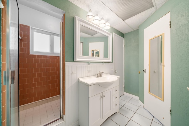 bathroom featuring tile patterned flooring, vanity, and walk in shower