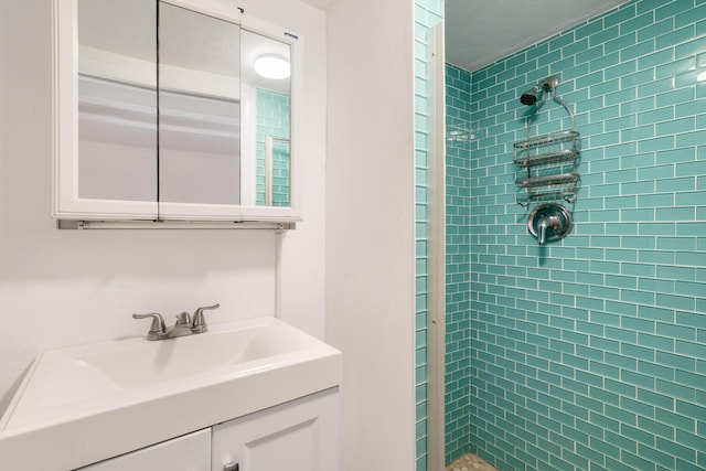 bathroom with tiled shower and vanity