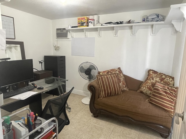 home office with an AC wall unit, light tile patterned floors, and baseboards