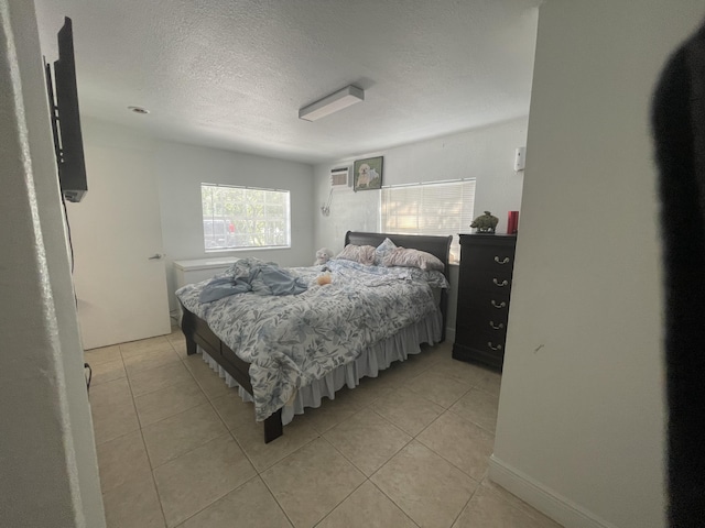 bedroom featuring light tile patterned floors and a textured ceiling