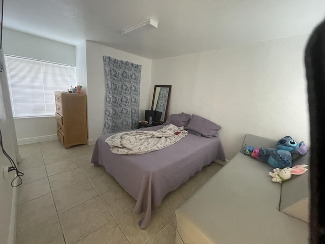bedroom featuring light tile patterned flooring and baseboards