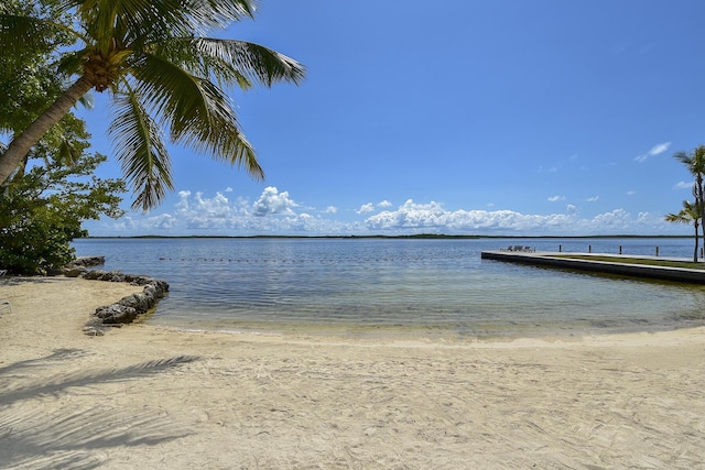 view of dock featuring a view of the beach and a water view