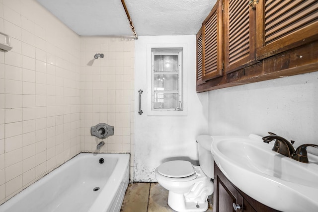 full bathroom featuring vanity, tiled shower / bath, a textured ceiling, and toilet