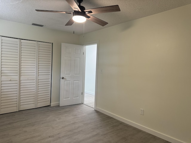 220 W Indies Rd, Tavernier, FL 33070 - unfurnished bedroom with a textured ceiling, wood finished floors, a closet, and ceiling fan