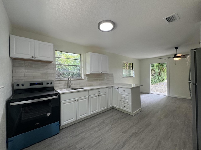 220 W Indies Rd, Tavernier, FL 33070 - kitchen featuring stainless steel electric range, freestanding refrigerator, a peninsula, light wood-style floors, and light countertops