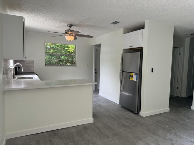 220 W Indies Rd, Tavernier, FL 33070 - kitchen with freestanding refrigerator, dark wood-style floors, a textured ceiling, a peninsula, and light countertops