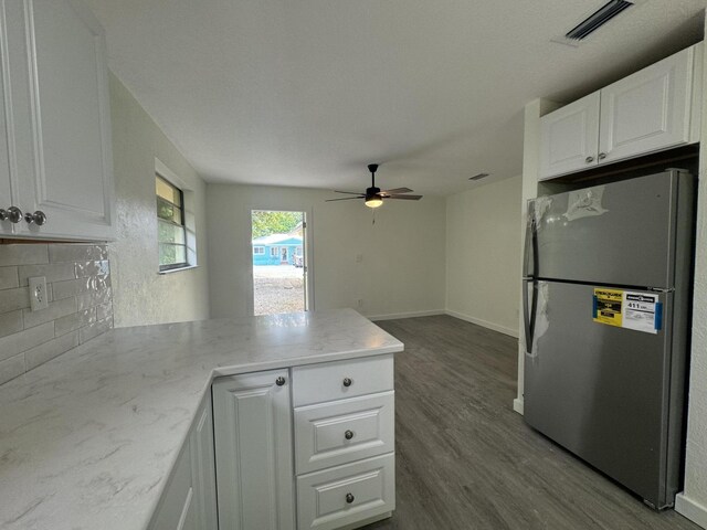 220 W Indies Rd, Tavernier, FL 33070 - kitchen featuring freestanding refrigerator, a peninsula, decorative backsplash, dark wood-style flooring, and white cabinetry