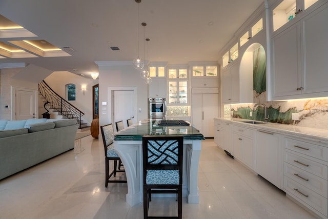 kitchen featuring stainless steel appliances, sink, a kitchen island, and white cabinets