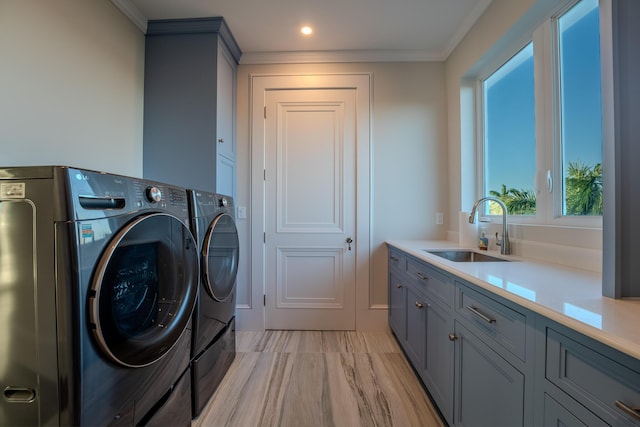 laundry room with sink, light hardwood / wood-style flooring, washer and clothes dryer, cabinets, and ornamental molding