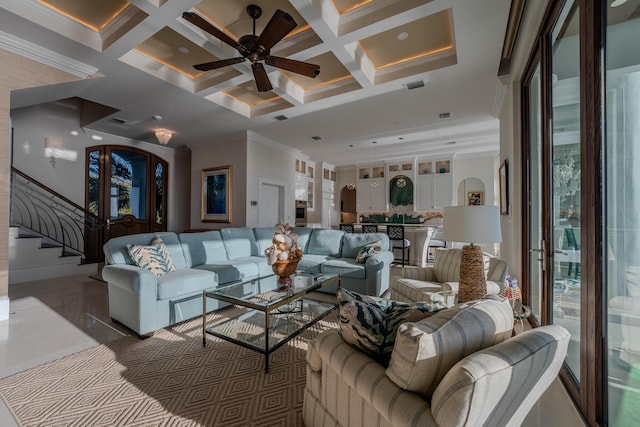 living room featuring beamed ceiling, ceiling fan, ornamental molding, and coffered ceiling