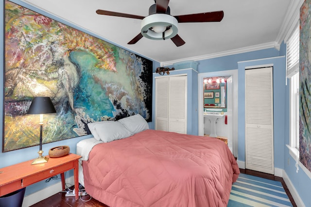 bedroom with ceiling fan, ensuite bathroom, ornamental molding, dark hardwood / wood-style flooring, and multiple closets