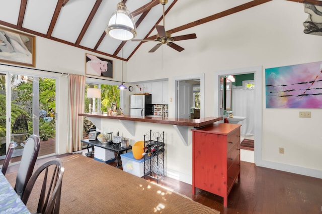 kitchen with stainless steel fridge, a breakfast bar, white cabinetry, dark hardwood / wood-style floors, and kitchen peninsula