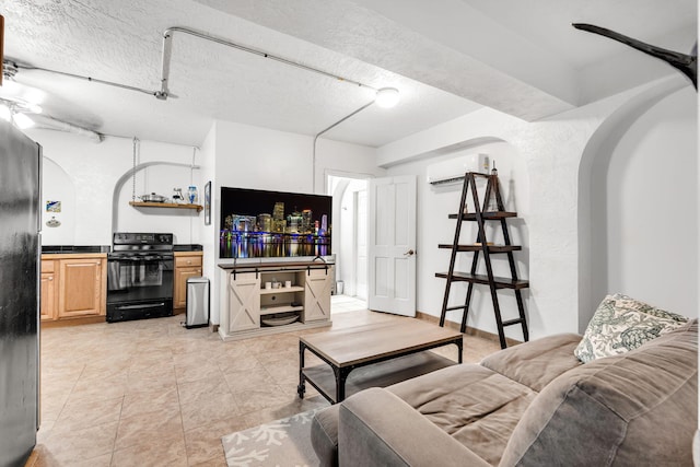 living room with light tile patterned flooring, a textured ceiling, and an AC wall unit