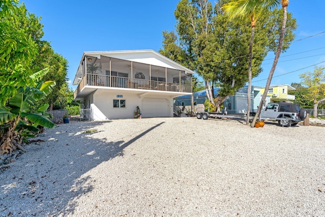 view of front of property featuring a garage and a sunroom