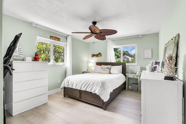 bedroom with light hardwood / wood-style floors and ceiling fan