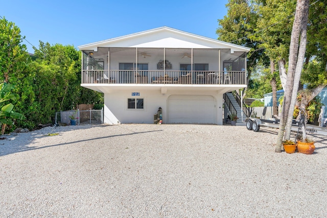 raised beach house with a garage and a sunroom